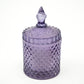 Plush Radiance Scented Wax Candle displayed in a beautiful mouth-blown glass vessel, showcasing its rich purple hue and artisanal craftsmanship.