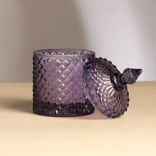 Plush Radiance Scented Wax Candle in elegant purple glass, showcasing its artisanal craftsmanship and warm glow.