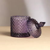 Plush Radiance Scented Wax Candle in elegant purple glass, showcasing its artisanal craftsmanship and warm glow.